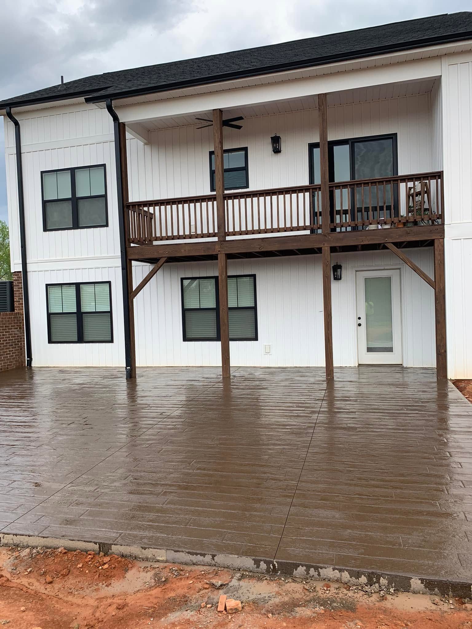 Decorative stamped concrete patio beneath a covered deck